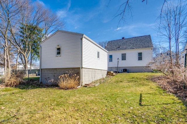 view of home's exterior featuring a yard, central AC unit, and a shingled roof