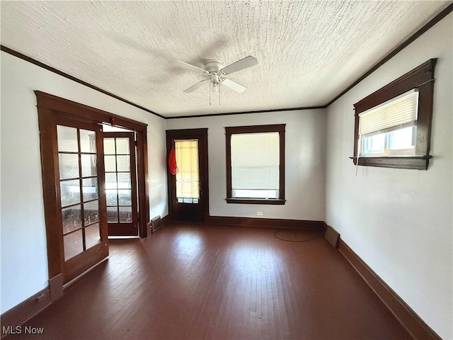 spare room with ornamental molding, hardwood / wood-style flooring, a textured ceiling, french doors, and baseboards