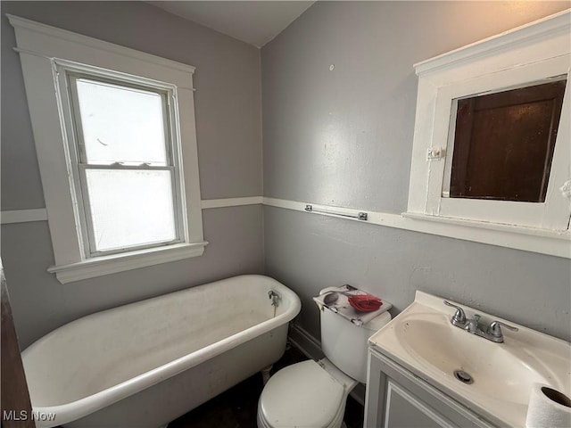 bathroom with a freestanding bath, vanity, and toilet