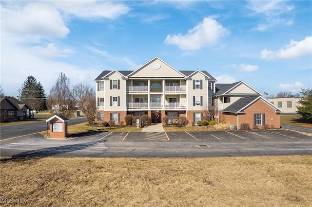 view of front of house featuring a balcony and uncovered parking