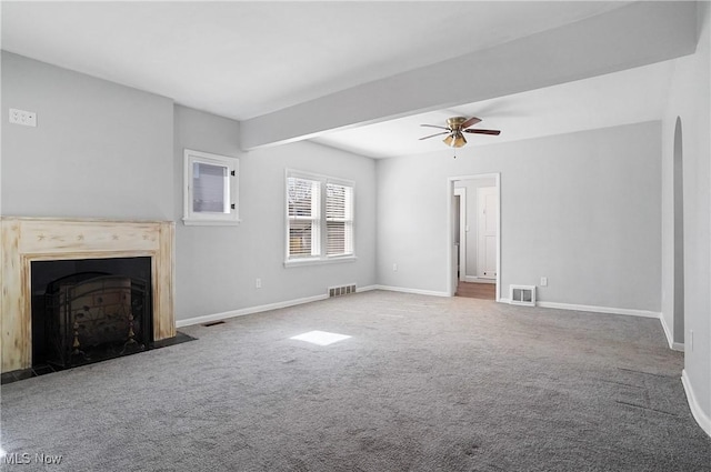 unfurnished living room featuring baseboards, visible vents, a fireplace with flush hearth, and carpet floors