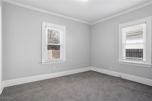 spare room featuring a wealth of natural light, dark carpet, and crown molding