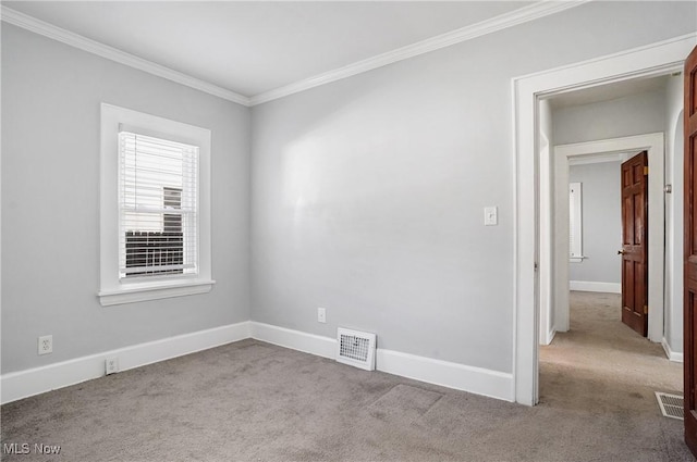 unfurnished room with visible vents, baseboards, carpet, and ornamental molding