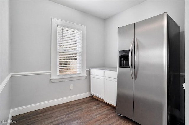 kitchen featuring dark wood finished floors, white cabinetry, stainless steel fridge, light countertops, and baseboards