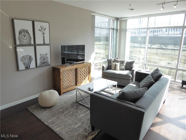 living area with a wall of windows, baseboards, and wood finished floors