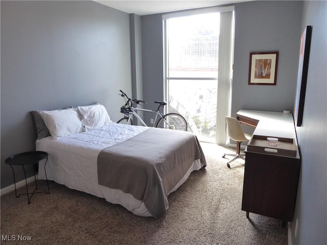 carpeted bedroom featuring a wall of windows