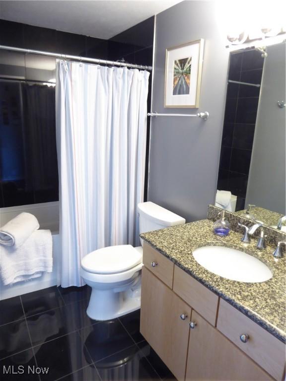 bathroom featuring tile patterned flooring, toilet, vanity, and a shower with curtain