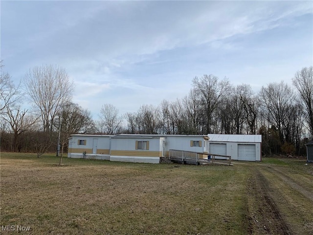 manufactured / mobile home with a front yard, a garage, and driveway