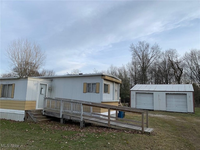 view of front of home featuring an outdoor structure and a front yard