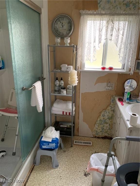 bathroom with a shower stall and visible vents