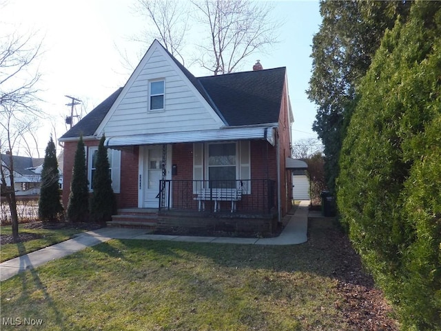 bungalow-style house with covered porch, a shingled roof, a chimney, a front lawn, and brick siding