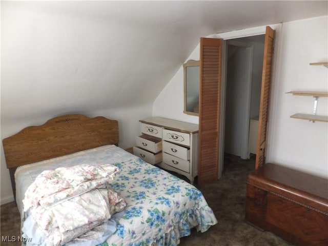 bedroom with lofted ceiling and dark colored carpet