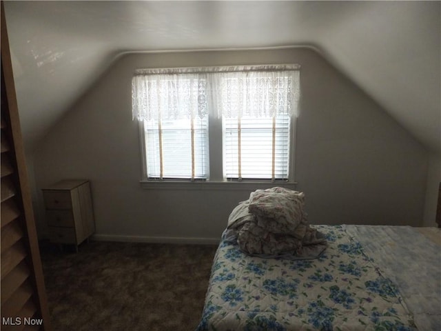 bedroom with baseboards, lofted ceiling, and carpet