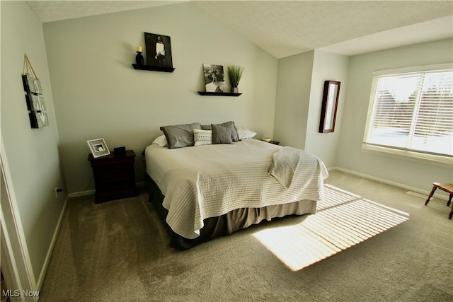 carpeted bedroom with baseboards and lofted ceiling