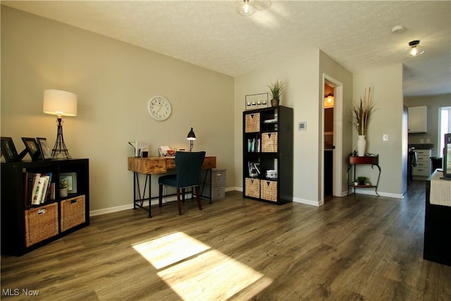 office area featuring dark wood finished floors, a textured ceiling, and baseboards