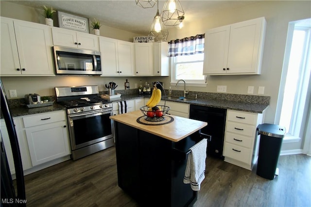 kitchen with appliances with stainless steel finishes, white cabinetry, and dark wood-type flooring