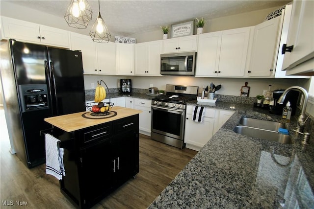 kitchen featuring a sink, stainless steel appliances, dark wood finished floors, and white cabinetry