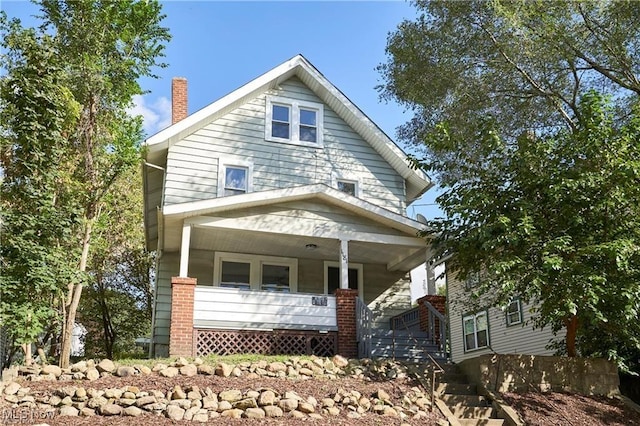 traditional style home featuring covered porch and a chimney