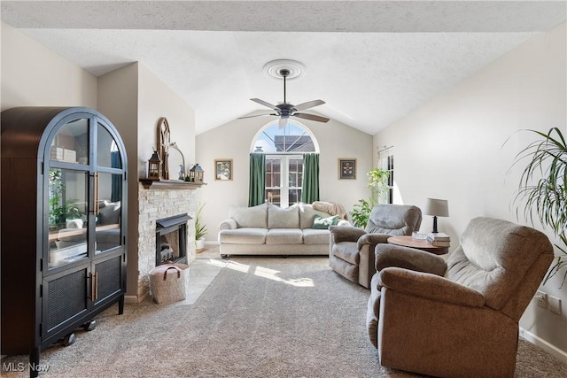 living area with carpet, a fireplace with flush hearth, vaulted ceiling, a textured ceiling, and a ceiling fan