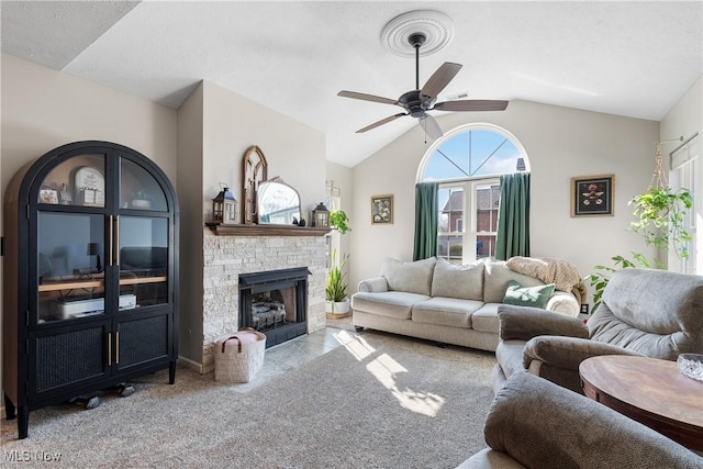 living area featuring lofted ceiling, carpet, ceiling fan, and a fireplace with flush hearth