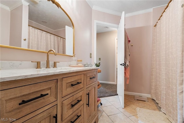 bathroom with tile patterned floors, vanity, crown molding, and baseboards