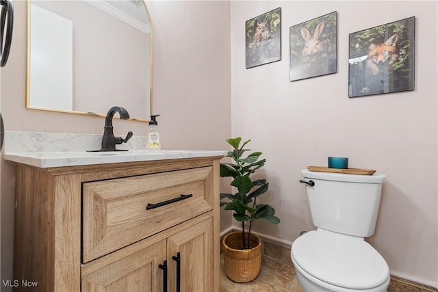 bathroom featuring toilet, vanity, and baseboards