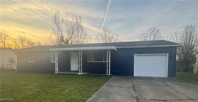 ranch-style house with covered porch, a lawn, an attached garage, and concrete driveway