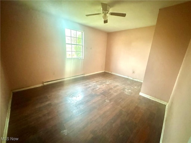 empty room featuring wood finished floors, baseboards, baseboard heating, and ceiling fan