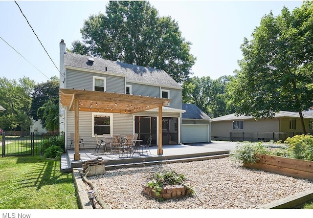 rear view of property with fence, a lawn, a chimney, a garage, and a pergola