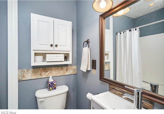 bathroom with a shower with curtain, toilet, and vanity