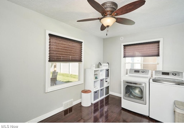 washroom with dark wood finished floors, laundry area, separate washer and dryer, and a healthy amount of sunlight