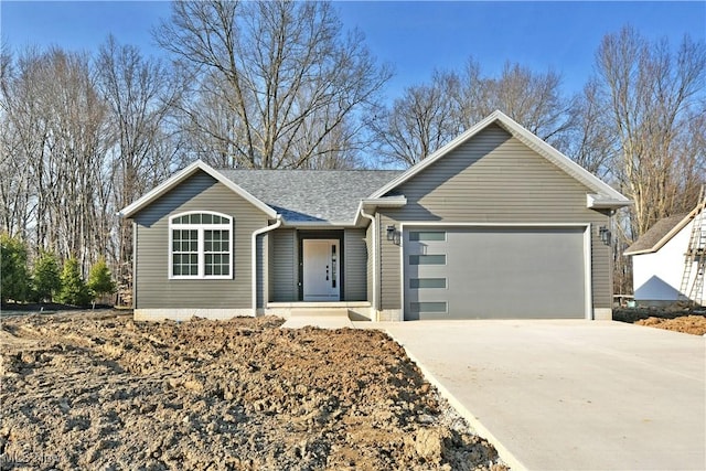 single story home featuring concrete driveway, an attached garage, and roof with shingles