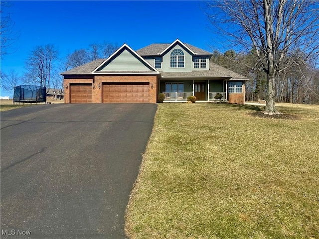 view of front facade with driveway, a porch, an attached garage, a front lawn, and brick siding