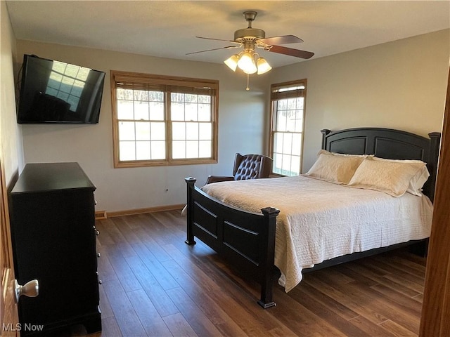 bedroom with dark wood-style floors, ceiling fan, and baseboards