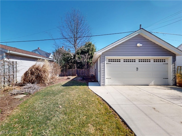 view of yard with a detached garage, fence, and an outbuilding