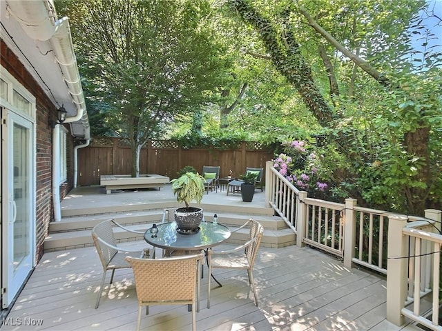 wooden deck featuring outdoor dining space and fence