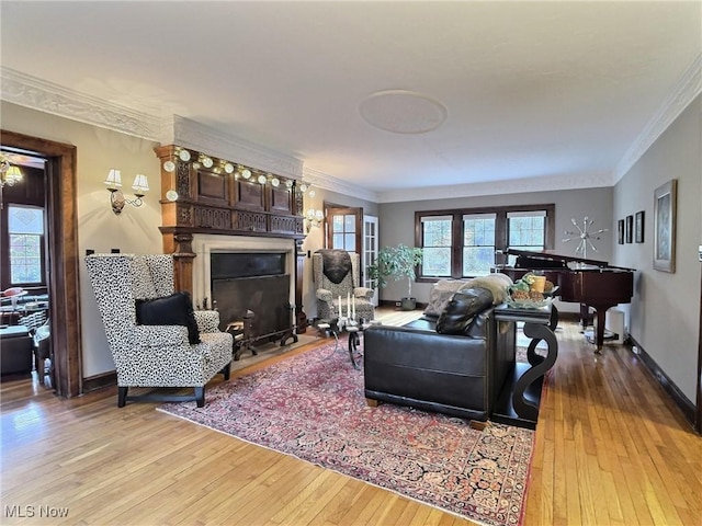 living room with a fireplace with flush hearth, light wood finished floors, and ornamental molding