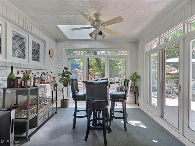 sunroom / solarium with a ceiling fan and a healthy amount of sunlight