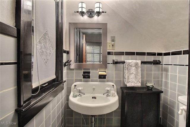 bathroom with tile walls and a sink