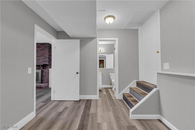 hallway with stairway, baseboards, and wood finished floors