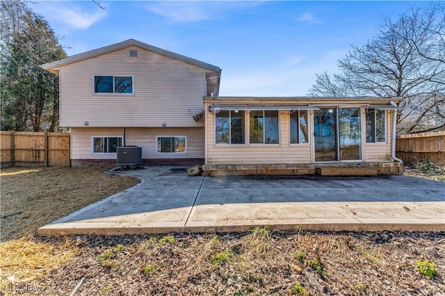 rear view of house with a fenced backyard, brick siding, and a patio