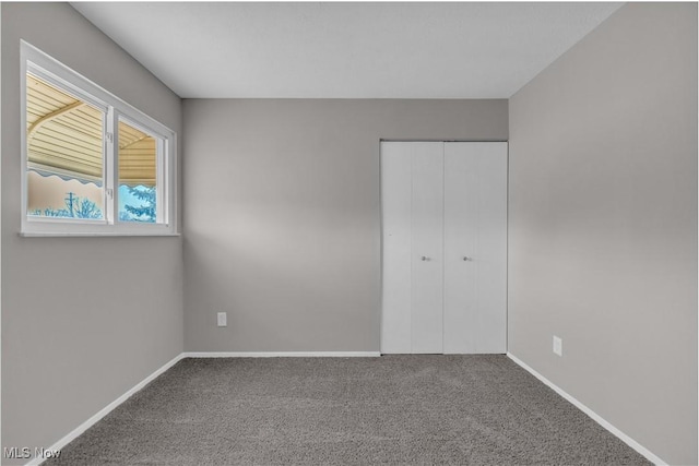 unfurnished bedroom with a closet, baseboards, and carpet