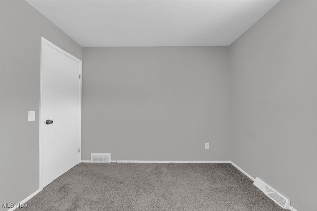 carpeted spare room with visible vents and baseboards