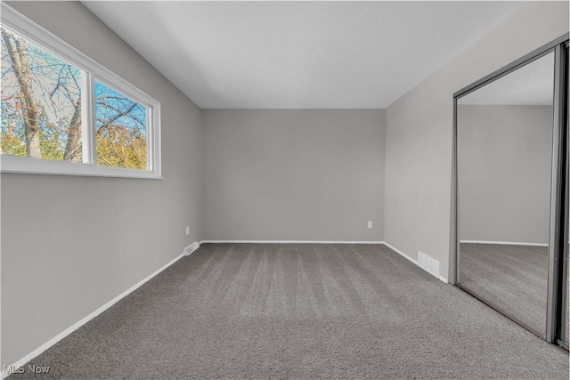 unfurnished bedroom featuring visible vents, baseboards, a closet, and carpet flooring