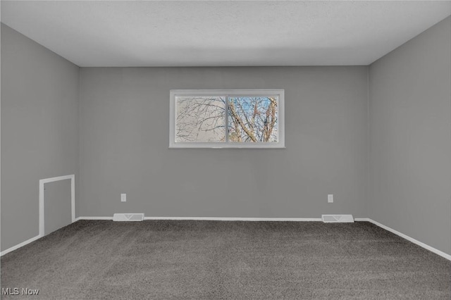 spare room featuring visible vents, carpet floors, and baseboards