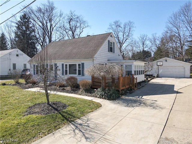 view of front of home with a shingled roof, a front lawn, a garage, a deck, and an outdoor structure