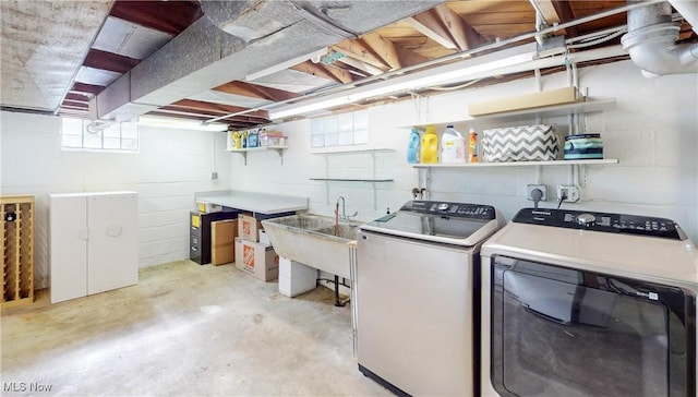 washroom with a sink, laundry area, and washer and clothes dryer