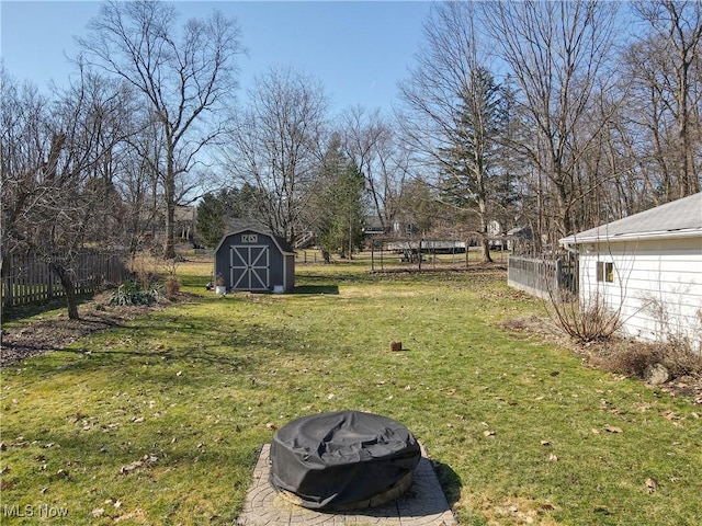 view of yard with a storage unit, an outdoor fire pit, an outdoor structure, and fence