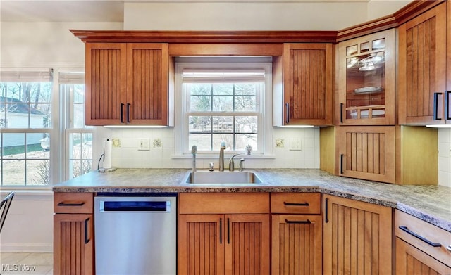 kitchen featuring backsplash, dishwasher, a healthy amount of sunlight, and a sink