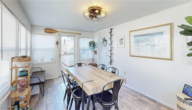 dining space with light wood finished floors and baseboards